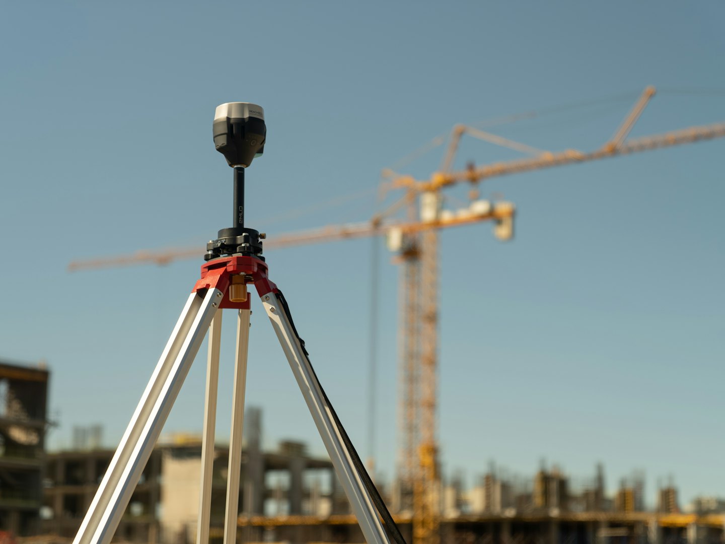 Ein GPS-Empfänger auf einem Stativ auf einer Baustelle.