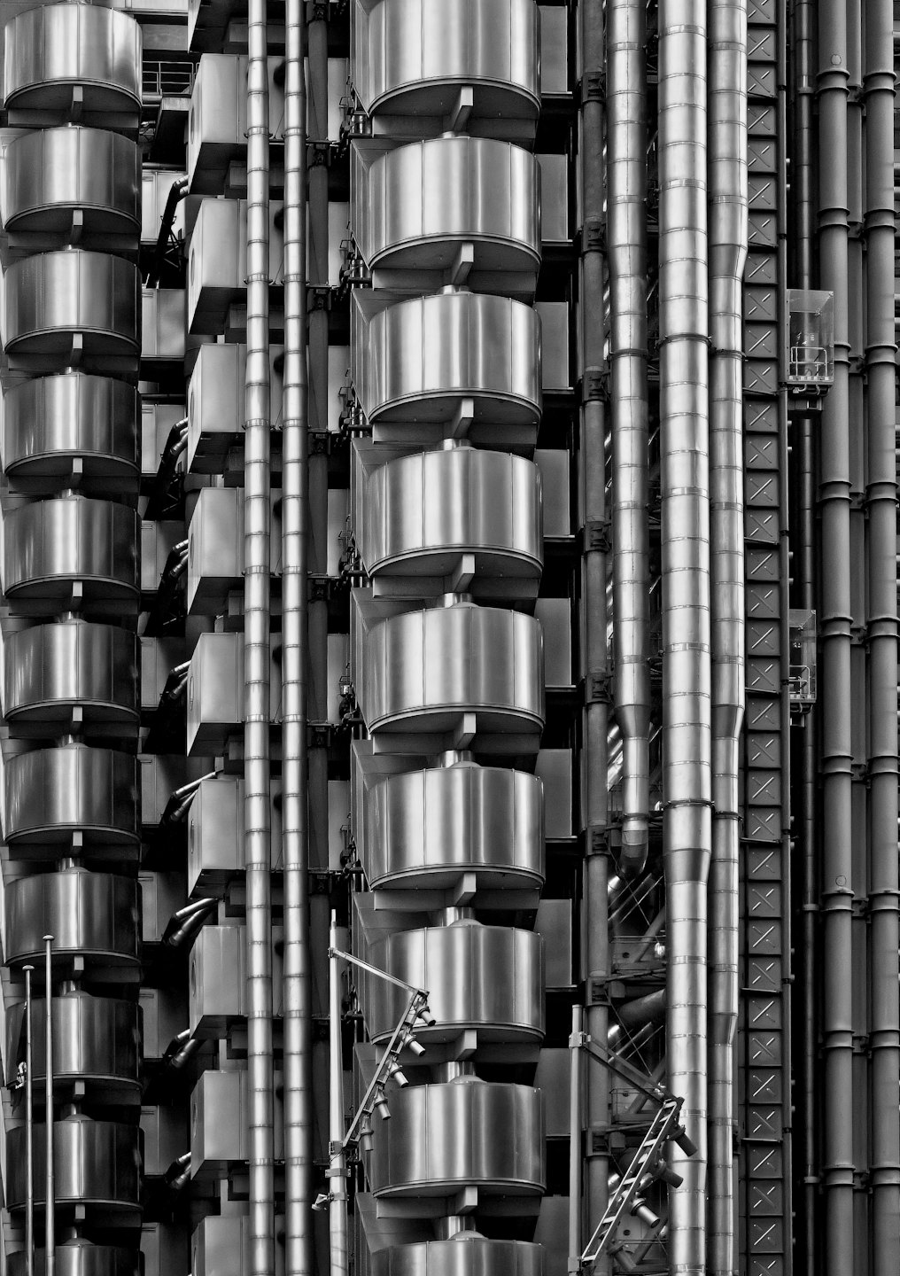 Metallrohre und Kanäle bilden ein komplexes Muster an der Außenfassade eines modernen Gebäudes.