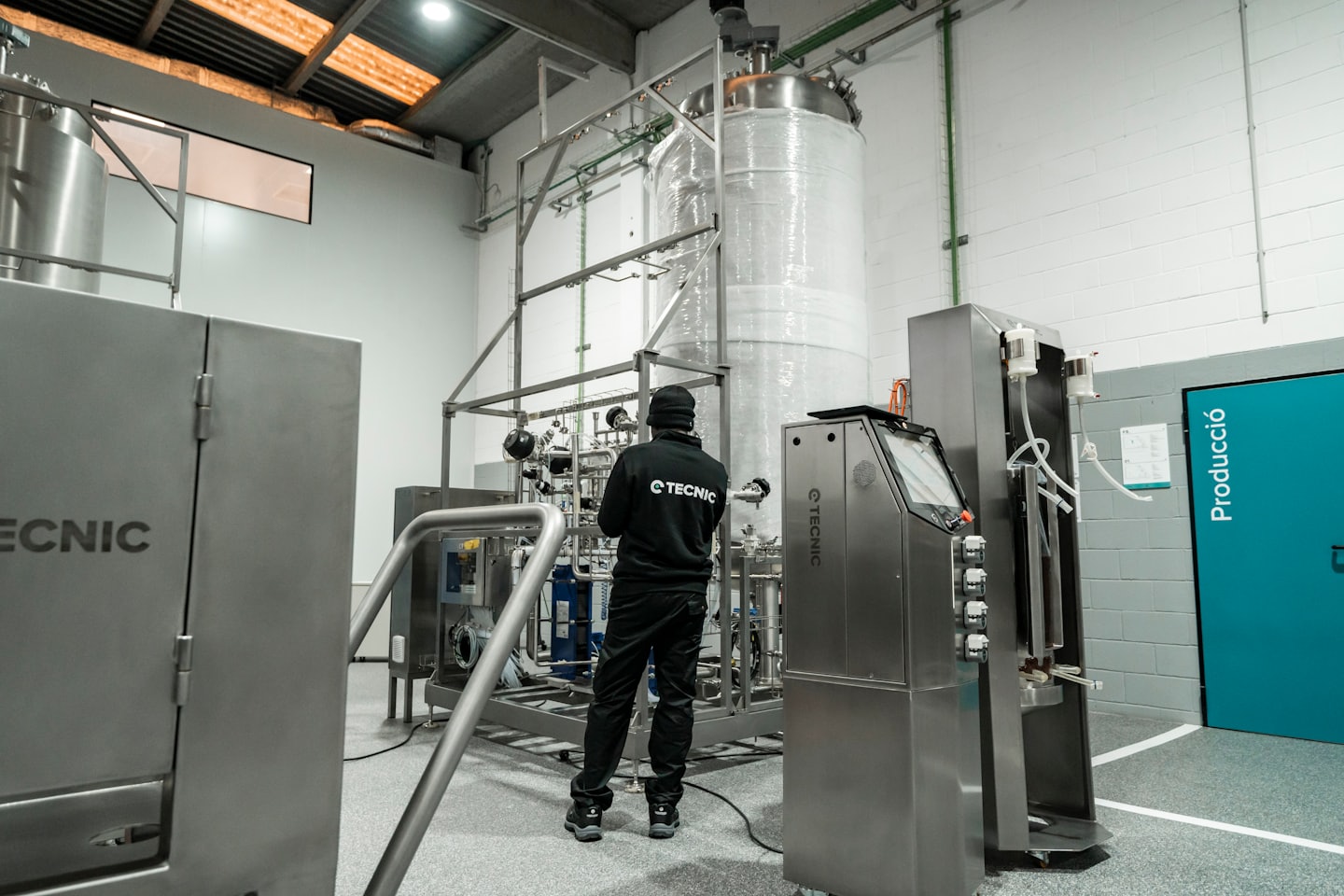 Techniker inspiziert komplexe industrielle Edelstahlmaschine.